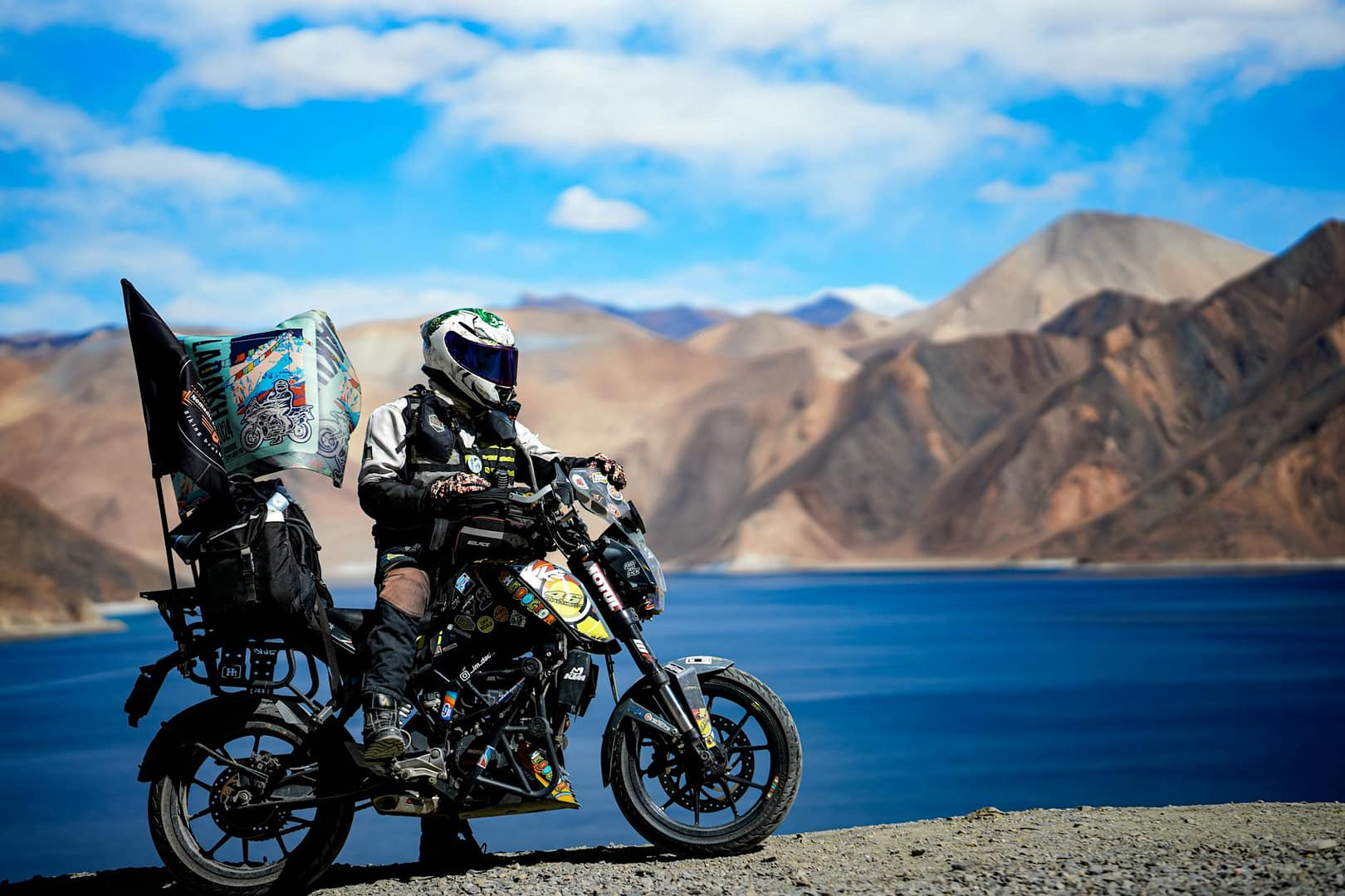 adventurous biker by pangong lake in ladakh