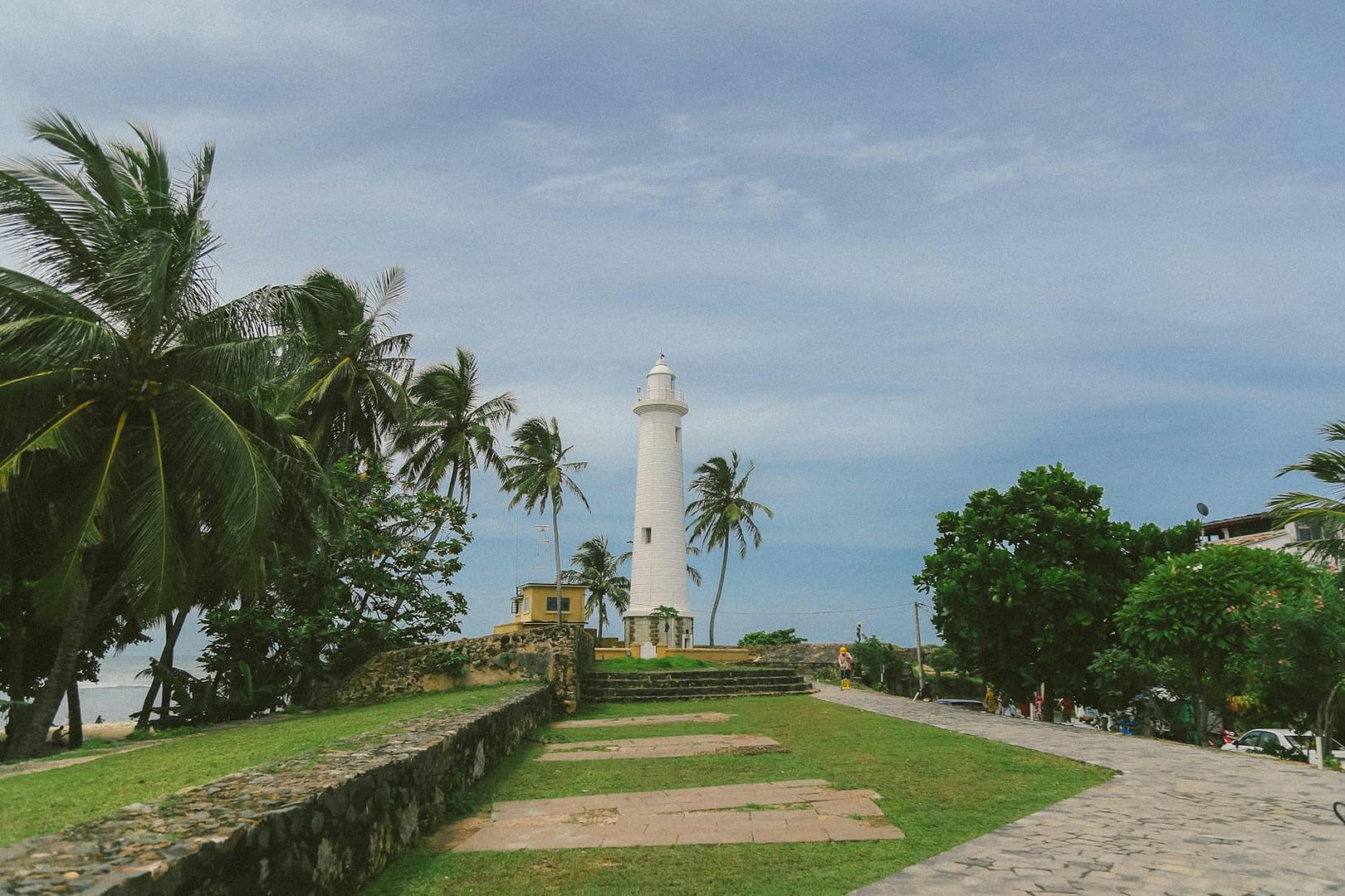 white lighthouse and green trees near the sea