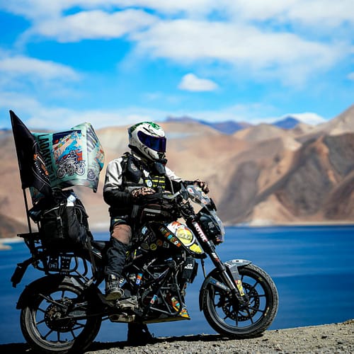 adventurous biker by pangong lake in ladakh