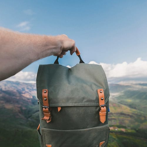 Hands holding traveler's backpack
