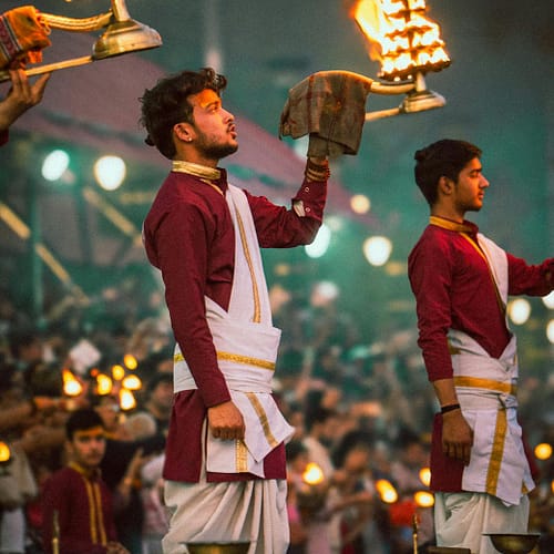 men holding lamp at hindu ceremony