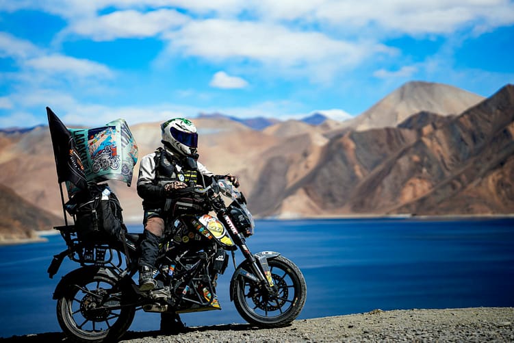 adventurous biker by pangong lake in ladakh