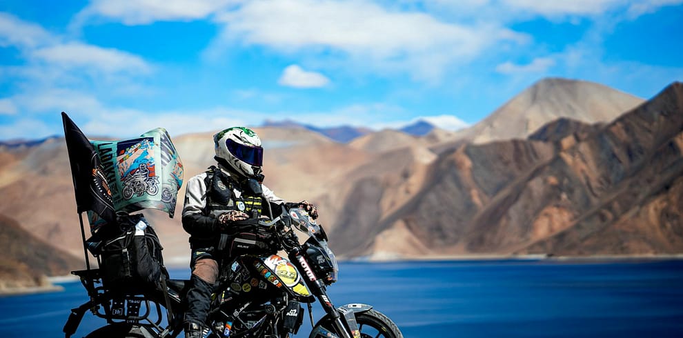 adventurous biker by pangong lake in ladakh